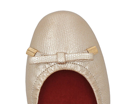 Close-up of gold wild-embossed full-grain leather ballet flats with an elegant bow and gold tips, featuring a removable RED ArchSupport orthotic, designed for flat feet, calcaneal spurs, and plantar fasciitis.