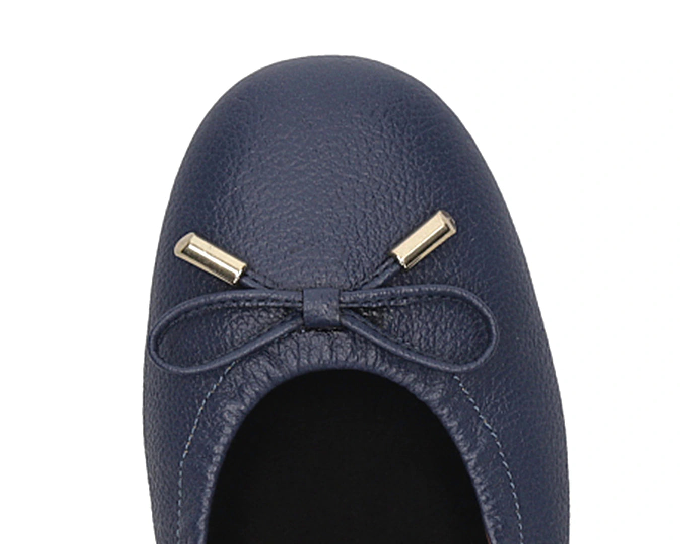 Close-up of the embossed grain leather on navy full-grain leather ballet flats with removable BLACK FlexiComfort orthotic for flat feet and 24k-gold-plated-bows.