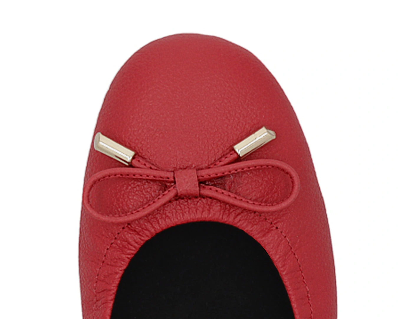 Close-up of the embossed grain leather on red full-grain leather ballet flats with removable BLACK FlexiComfort orthotic for flat feet and 24k-gold-plated-bows.