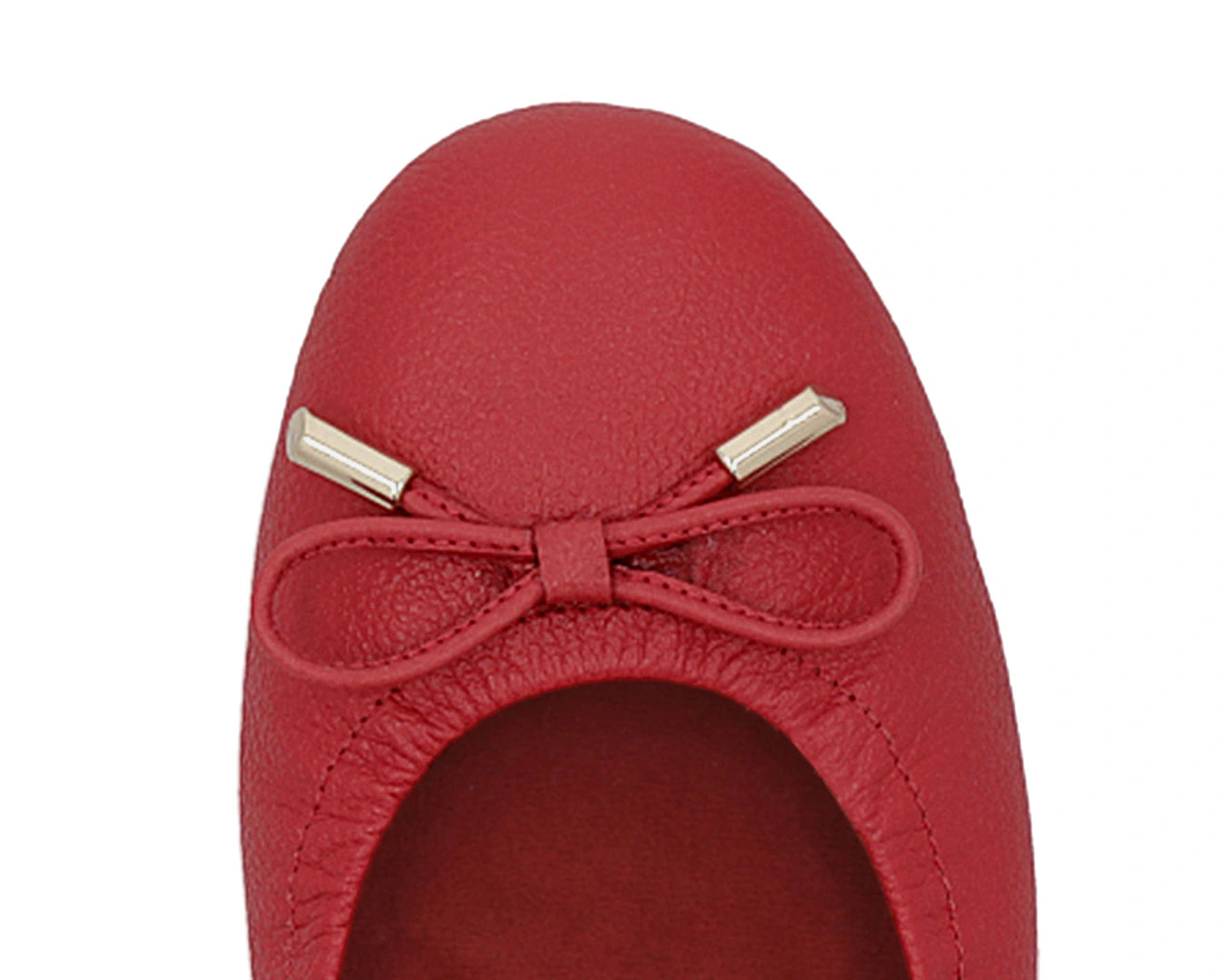 Close-up of the embossed grain leather on red full-grain leather ballet flats with removable RED ArchSupport orthotic for flat feet, calcaneal spurs, and plantar fasciitis and 24k-gold-plated-bows.
